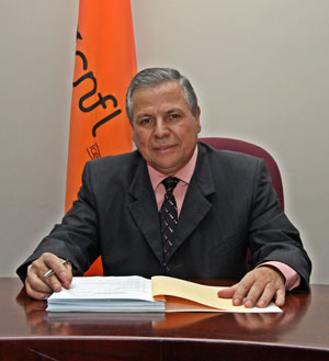 Imagen del Sr. Víctor Solís Rodríguez, detrás de Él la bandera de la CNFL,S.A.